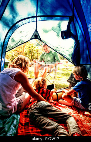 Kids and mother using tablet while father looking at the map Stock Photo