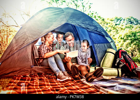 Family looking at the digital tablet in the tent Stock Photo