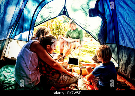 Kids and mother using tablet while father looking at the map Stock Photo