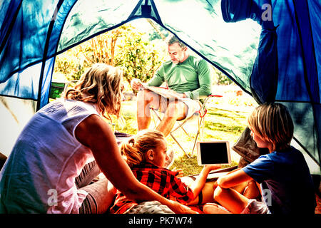 Kids and mother using tablet while father looking at the map Stock Photo