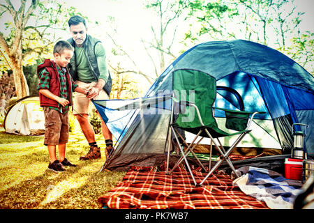 Father and son setting up the tent at campsite Stock Photo