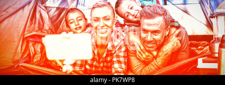 Smiling family taking selfie in the tent Stock Photo