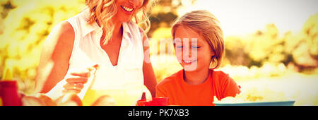 Happy mother and son having meal in park Stock Photo