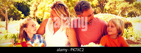Happy family interacting with each other while having meal in park Stock Photo