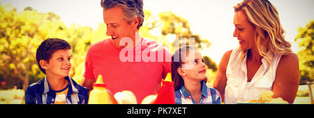 Happy family interacting with each other while having meal in park Stock Photo