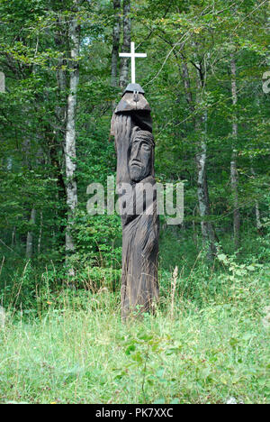 One of a series of carved wooden statues which line the route to mass graves site at Jama Pod Krenom in Kočevski Rog, Slovenia Stock Photo