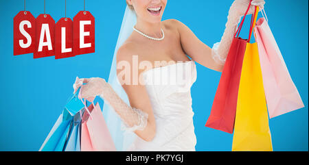 Composite image of bride holding shopping bags over white background Stock Photo