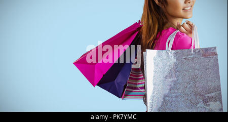 Composite image of smiling asian woman with shopping bags Stock Photo
