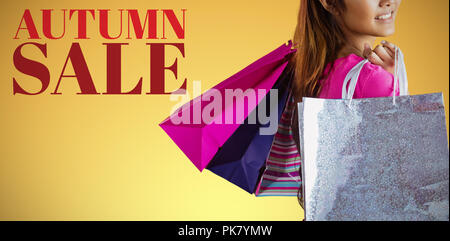 Composite image of smiling asian woman with shopping bags Stock Photo