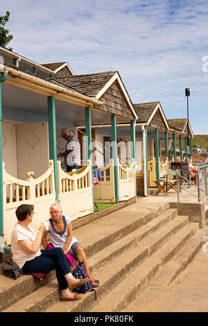 UK, England, Yorkshire, Filey, visitors drinking tea at Coble Landing beach hut steps Stock Photo