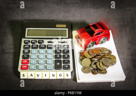 Saving money concept, a car and a pile of coins beside a calculator Stock Photo