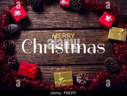 Merry Christmas text with gifts on wood Stock Photo