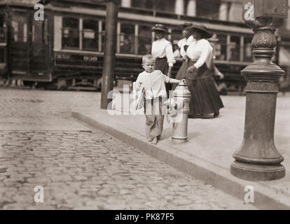 Child newspaper vendor, New York.  Taken 1909.  After a photograph by Lewis Hine, 1874-1940.  Hine was a sociology teacher who used photography to record social problems and spur reform. Stock Photo