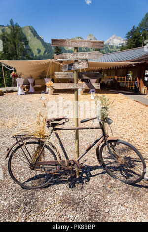 Rusty Bicycle and Wooden Photo Booth Direction Sign at Shabby Chic Wedding Stock Photo