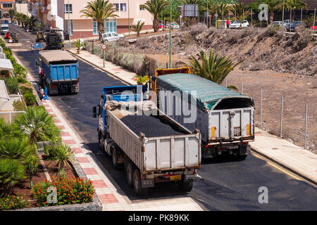 Truckloads of asphalt ready for laying a new layer of tarmac on the road Stock Photo