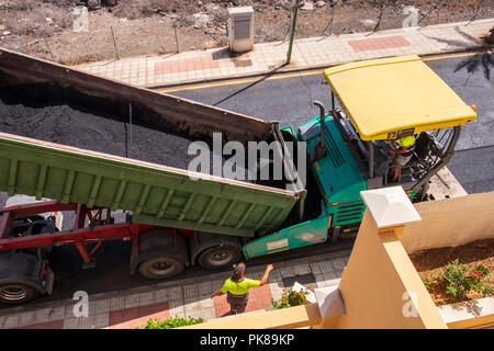 Truckloads of asphalt ready for laying a new layer of tarmac on the road Stock Photo