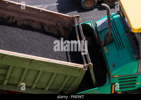 Truckloads of asphalt ready for laying a new layer of tarmac on the road Stock Photo