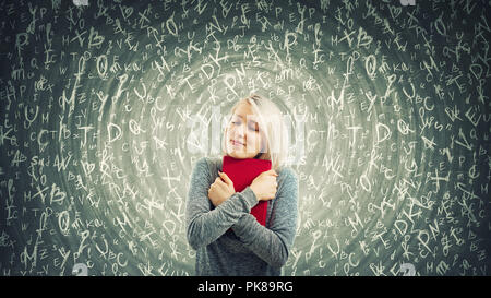 Young woman student holding a red book to chest with closed eyes. A warm hug show the love for knowledge and different letters flying around. Hypnotic Stock Photo