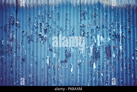 Corrugated metal fence with peeling paint, color toning applied. Stock Photo
