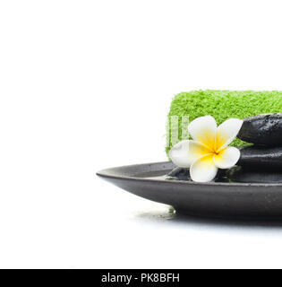 Spa Set with stones and towel and leaves on black plate Stock Photo