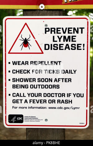 A sign in the woods at the Kingdom Trails mountain bike area warning of Lyme Disease from ticks Stock Photo