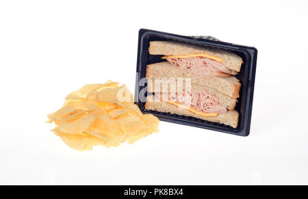 Smoked turkey and cheese prepared takeaway sandwich in packet with potato crisps or chips on white background Stock Photo