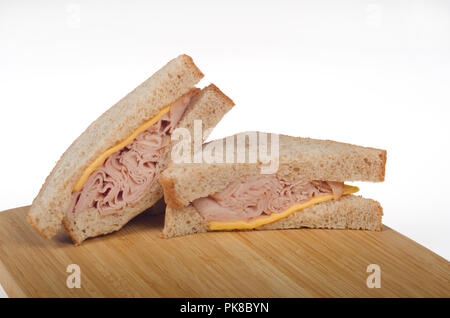 Turkey and cheese sandwich on whole wheat bread with wood cutting board Stock Photo