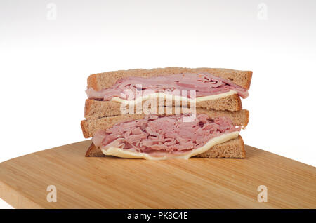 Ham and Cheese sandwich on whole wheat bread on a wood cutting board Stock Photo
