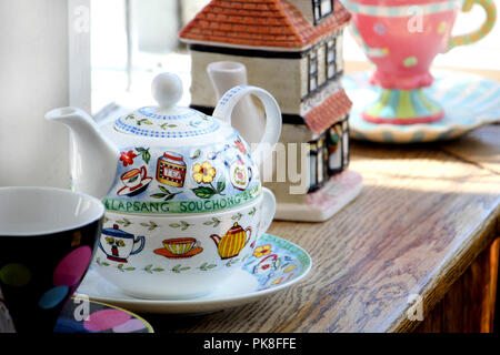 Corfe, England - June 03 2018:Decorative colorful Lapsang Souchon tea pot, on a windowsill with other china items in a tea shop Stock Photo
