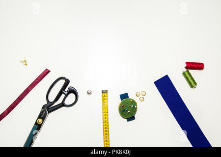 set of seamstresses, handicrafts Ribbons, threads, scissors, needles, accessories are on the table top view of flutlairs, - metering, buttons and pins Stock Photo