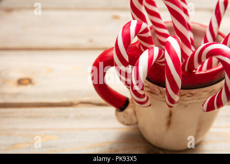 Christmas candy canes in cup on white background Stock Photo - Alamy