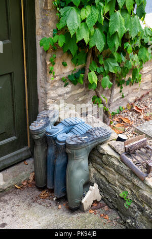 Wellington boots outside a cotswold cottage front door. Tetbury, Gloucestershire, England Stock Photo