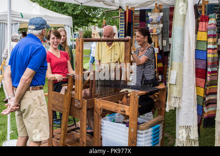 A woman weaving at an arts and craft fair in Lenox, MA Stock Photo