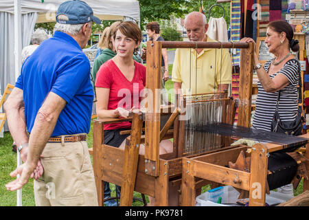 A woman weaving at an arts and craft fair in Lenox, MA Stock Photo