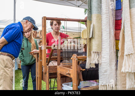 A woman weaving at an arts and craft fair in Lenox, MA Stock Photo