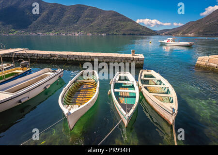 Three small fishing boats on the shore in the beautiful Perast town in the Kotor Bay, Montenegro Stock Photo