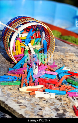 Clothespins. Colorful clothespin in the basket, stand on the table in the garden. Cloth clothespins. Stock Photo