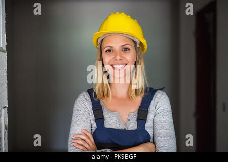 Young woman worker with a yellow helmet on the construction site. Stock Photo