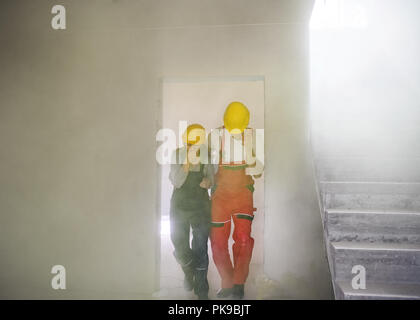 Woman and man workers suffocating at the construction site. Stock Photo