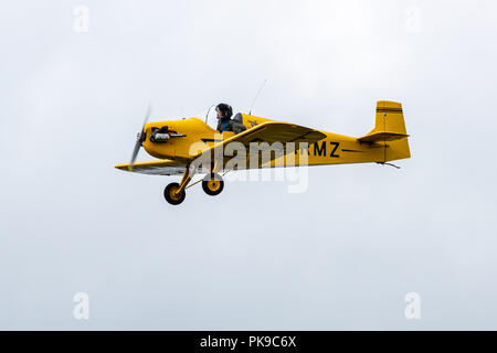 A bright yellow Tiger Club D31 Turbulent single seater in level flight during an air display Stock Photo