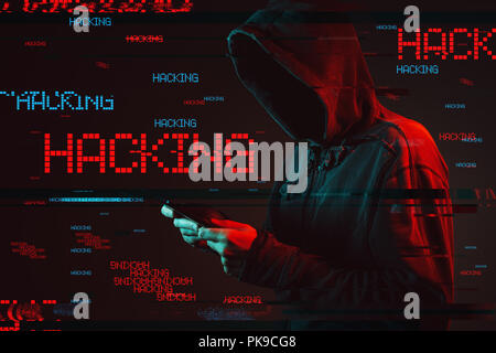 Computer hacking concept with faceless hooded male person using tablet, low key red and blue lit image and digital glitch effect Stock Photo