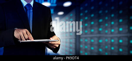 Businessman working with VR wide blank screen computer on server room in background. Stock Photo