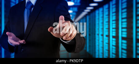 Businessman working with VR wide blank screen computer on server room in background. Stock Photo
