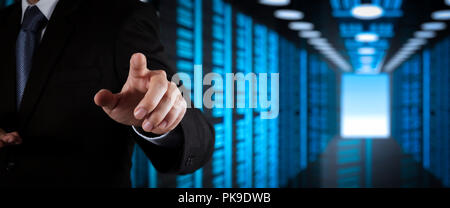 Businessman working with VR wide blank screen computer on server room in background. Stock Photo