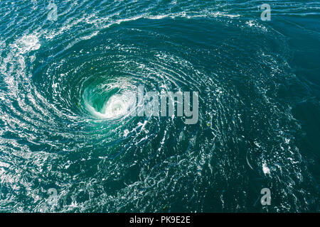 A powerful whirlpool generated at the surface of the water by a turbine A powerful whirlpool generated at the surface of the water by a turbine