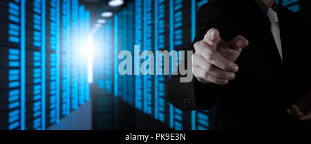 Businessman working with VR wide blank screen computer on server room in background. Stock Photo