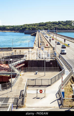 The Rance tidal power station near Saint-Malo in Brittany, France, with the lock crossing the dam and vehicles crossing the estuary on the dam. Stock Photo