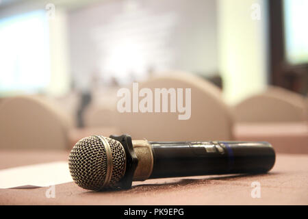 The microphone is located on prepared table at the center of the room with a white tables cloth and chairs and prepare before the start of  seminar me Stock Photo