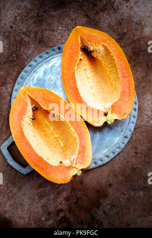 Ripe papaya without seeds cut into two halves Stock Photo