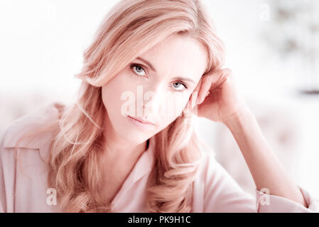 Tired young woman feeling unhappy and putting her head on her hand Stock Photo